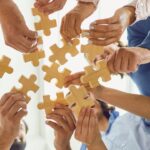 Graphical abstracts can bridge the gap between complex data and readers. The image shows people putting together puzzle pieces to represent this idea.